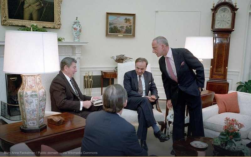 1/18/1983 President Reagan during a meeting with Rupert Murdoch, Charles Wick (not in photo), Roy Cohn, Thomas Bolan in the Oval Office. Reagan seated at left; presumably back of Bolan's head seen center left; Rupert Murdoch seated center right; Roy Cohn standing at right. — related to Elite Media Control Conspiracy