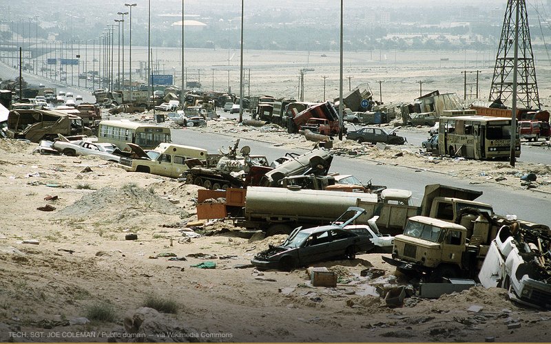 Demolished vehicles line Highway 80, also known as the "Highway of Death", the route fleeing Iraqi forces took as they retreated from Kuwait during Operation Desert Storm. The tank visible in the center of the picture is either a Type 59 or a Type 69 as evidenced by the dome-shaped ventilator on the top of the turret and the headlamps on the right fender. — related to NATO Expansion — Broken Promise to Russia